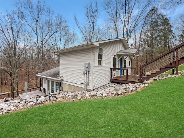 back of property featuring a wooden deck and a yard