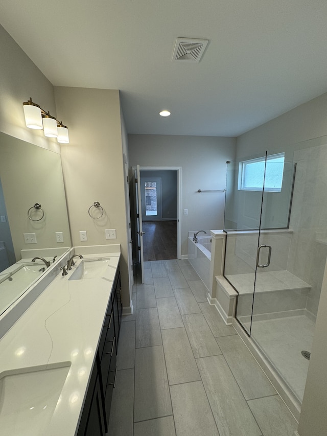 bathroom with vanity, wood-type flooring, and separate shower and tub