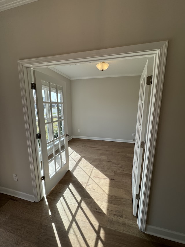 empty room with french doors, crown molding, and hardwood / wood-style floors