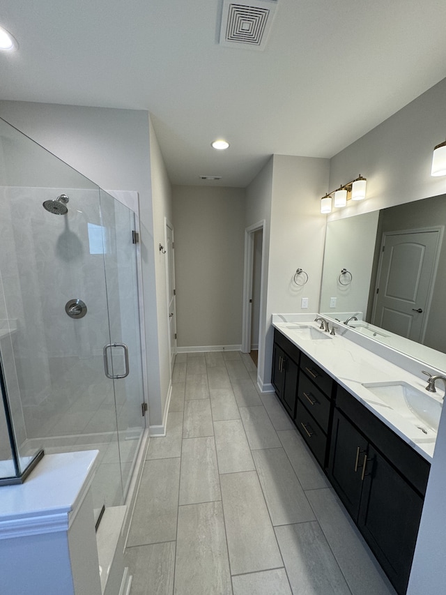 bathroom with vanity and a shower with door