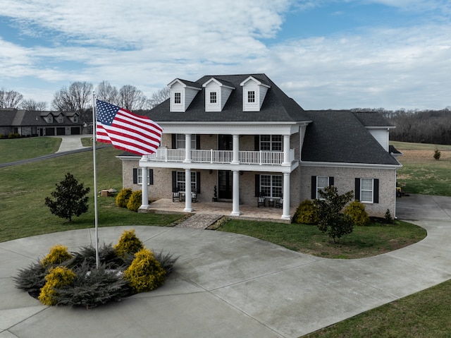 view of front of home featuring a front lawn and a balcony