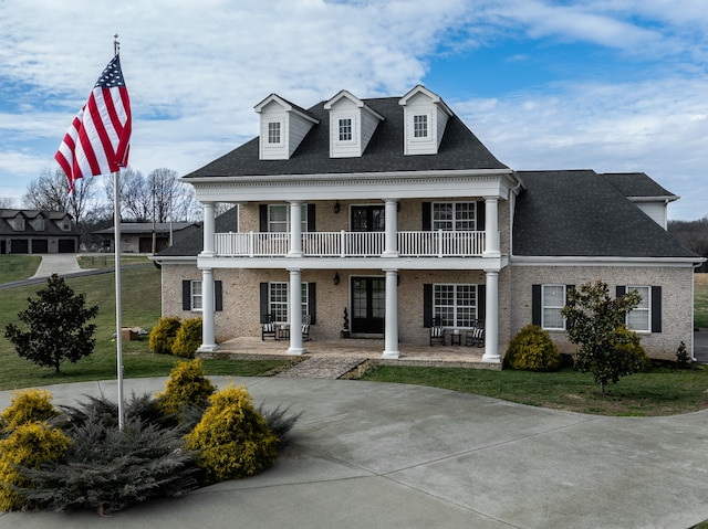 view of front facade with a balcony and a front yard