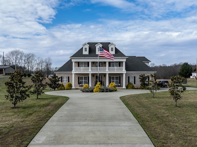 view of front of house with a balcony and a front lawn