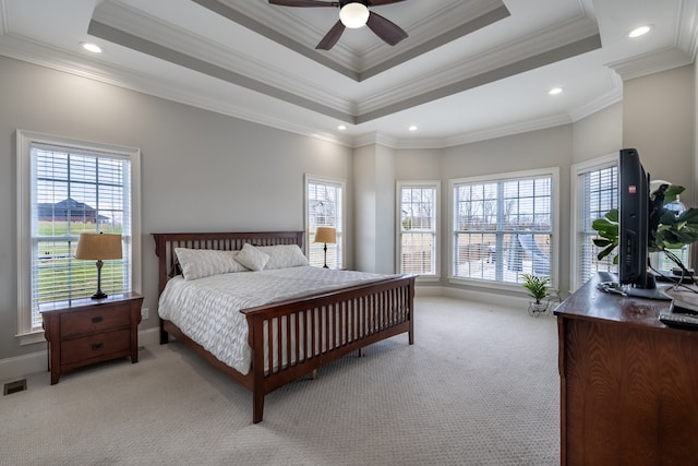 bedroom with light carpet, a raised ceiling, ornamental molding, and multiple windows