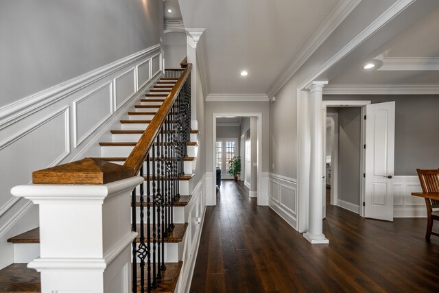 stairway featuring ornate columns, dark hardwood / wood-style floors, and crown molding