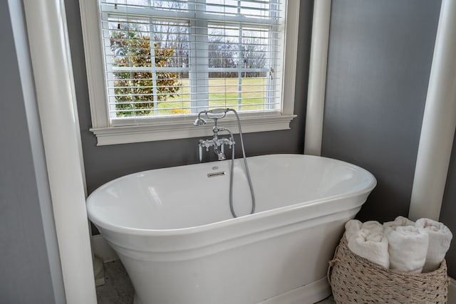 bathroom with a bath to relax in and a wealth of natural light