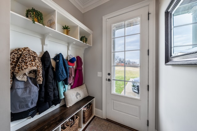 mudroom with dark tile floors and crown molding