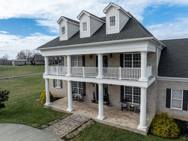 view of front of property with a front lawn and a balcony