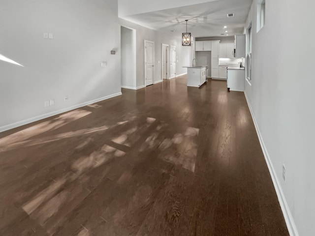 unfurnished living room featuring dark hardwood / wood-style flooring and sink