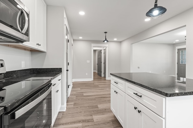 kitchen with hanging light fixtures, white cabinetry, light hardwood / wood-style floors, and stainless steel appliances