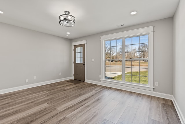 spare room with a notable chandelier and hardwood / wood-style floors