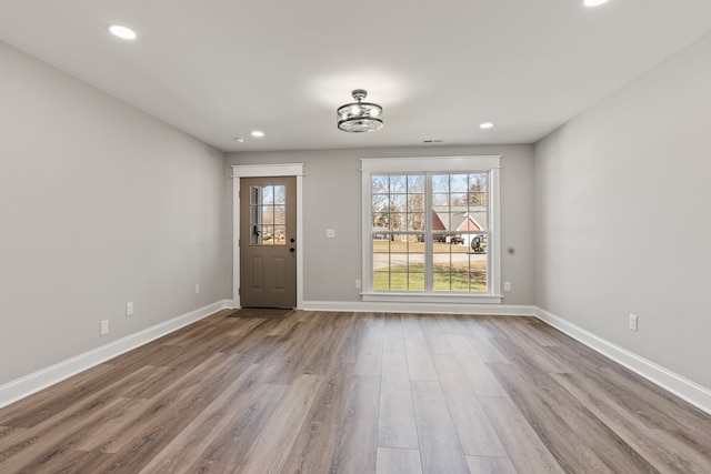 spare room with a notable chandelier and dark hardwood / wood-style flooring