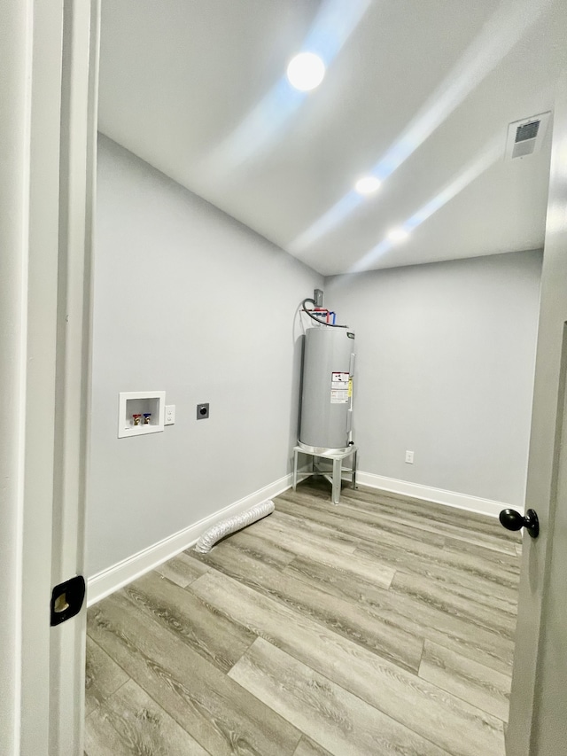 laundry room featuring light wood-type flooring, electric dryer hookup, hookup for a washing machine, and water heater