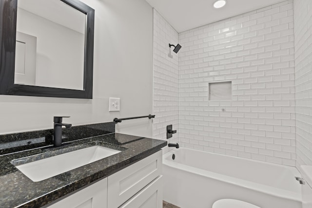 full bathroom featuring tiled shower / bath, toilet, and vanity