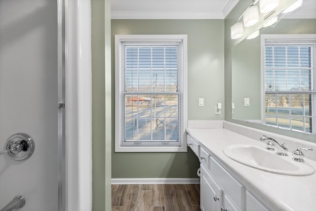 bathroom featuring ornamental molding, vanity, hardwood / wood-style floors, and a wealth of natural light