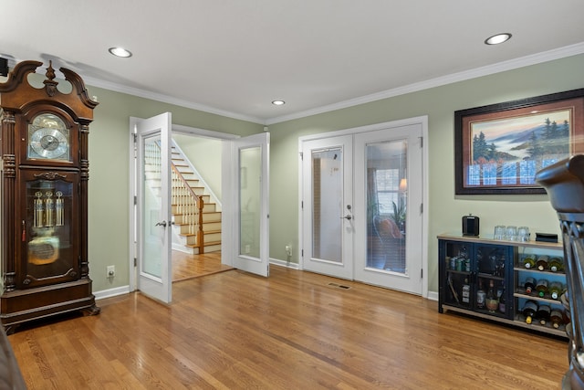 living room with french doors, light hardwood / wood-style flooring, and ornamental molding