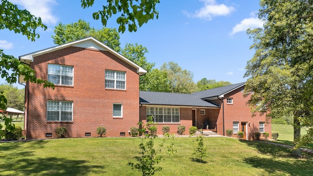 rear view of house featuring a yard