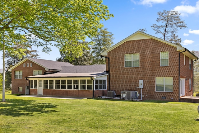 back of house with a sunroom, a yard, and central air condition unit