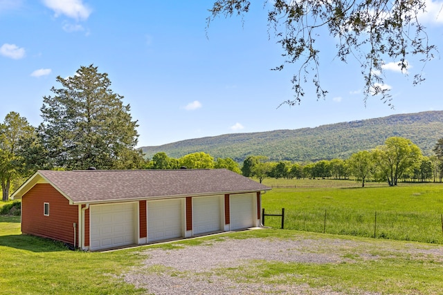 garage featuring a mountain view and a yard