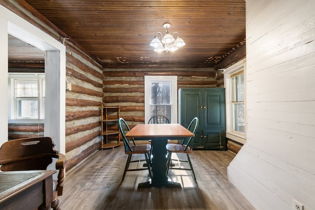 dining area featuring a notable chandelier, dark hardwood / wood-style flooring, log walls, and wooden ceiling