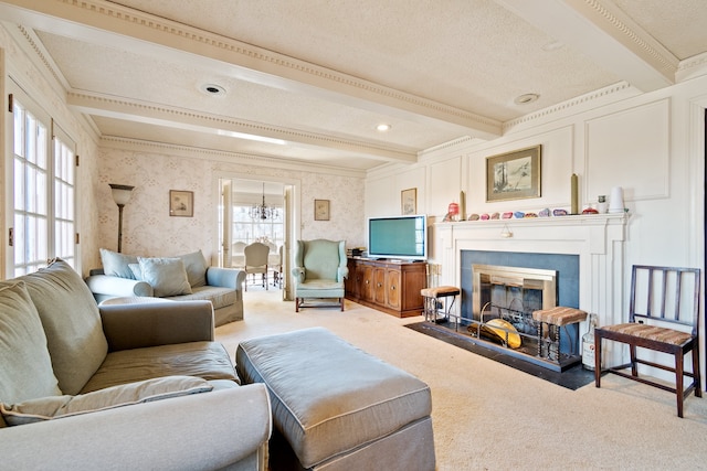 living room with beamed ceiling, carpet, a tile fireplace, a textured ceiling, and ornamental molding