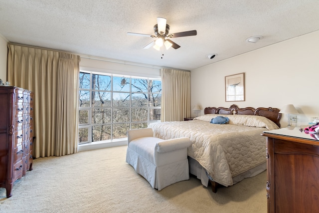 carpeted bedroom featuring a textured ceiling and ceiling fan