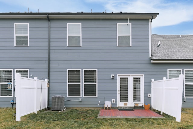 rear view of property with central AC unit, a patio, and a yard