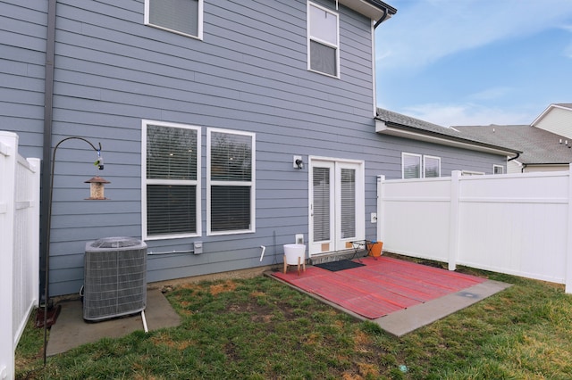 back of house with a patio, central air condition unit, and a lawn