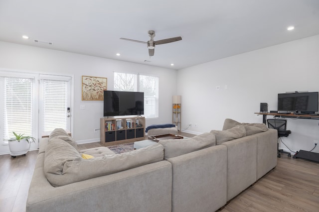 living room featuring light hardwood / wood-style flooring and ceiling fan