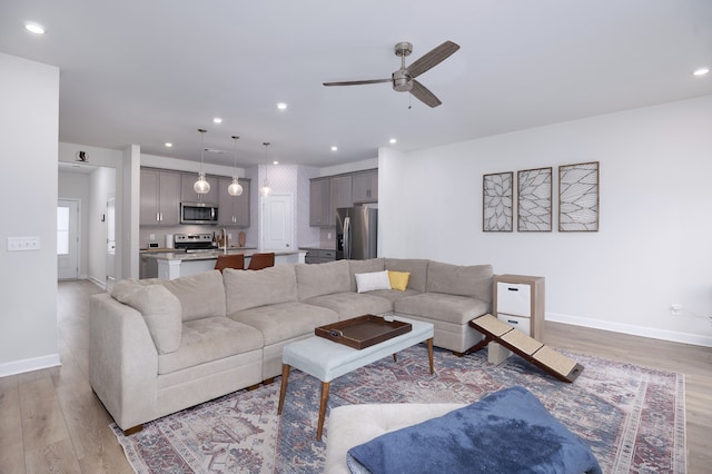 living room featuring ceiling fan and light hardwood / wood-style flooring