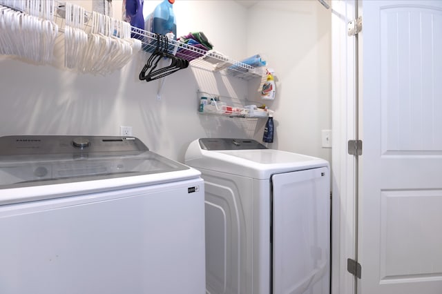 clothes washing area with washer and clothes dryer