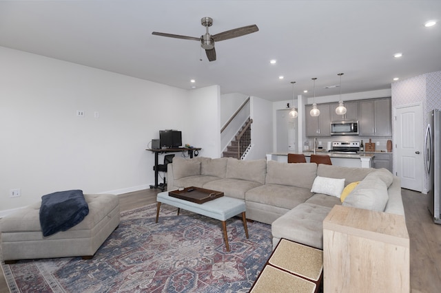 living room with ceiling fan, dark hardwood / wood-style floors, and sink