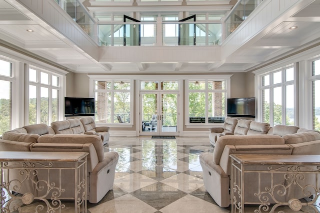 living room with light tile flooring, coffered ceiling, and a healthy amount of sunlight