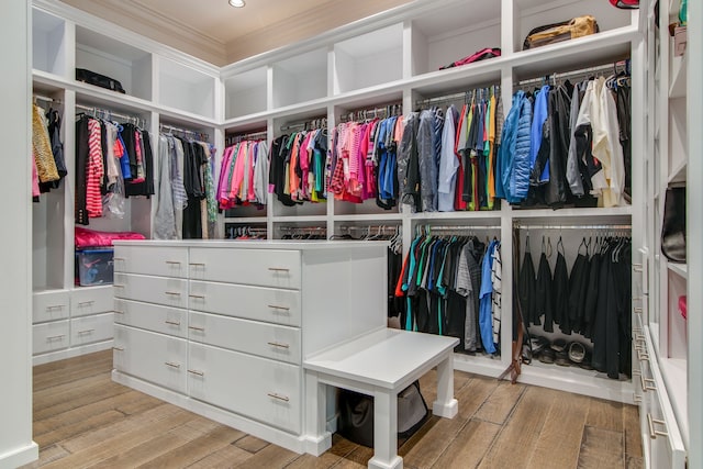 walk in closet with light hardwood / wood-style flooring