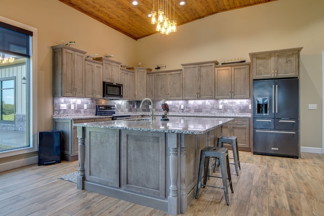 kitchen with wooden ceiling, black appliances, backsplash, light wood-type flooring, and an inviting chandelier