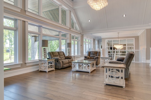 living room featuring high vaulted ceiling, light wood-type flooring, and an inviting chandelier