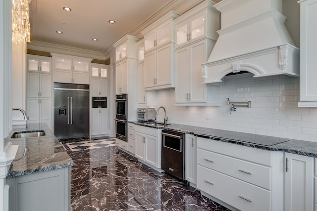 kitchen with sink, dark stone counters, backsplash, stainless steel appliances, and white cabinetry