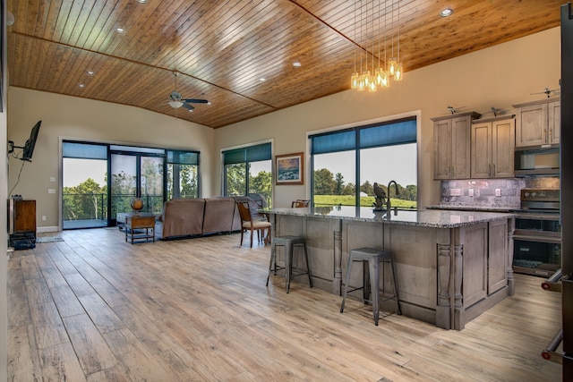 kitchen featuring appliances with stainless steel finishes, backsplash, light hardwood / wood-style floors, and wooden ceiling