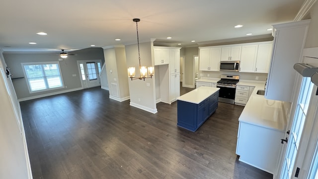 kitchen featuring dark hardwood / wood-style floors, pendant lighting, appliances with stainless steel finishes, blue cabinetry, and ceiling fan with notable chandelier