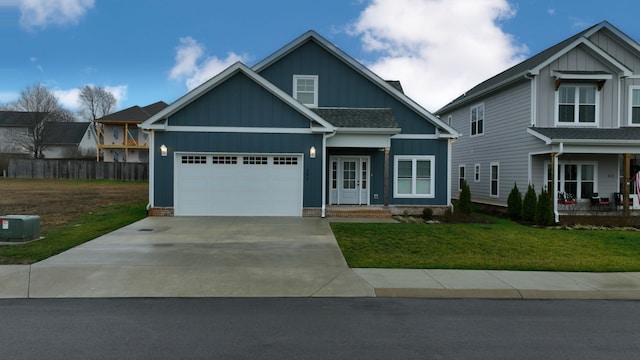 craftsman house with a front yard, covered porch, and a garage