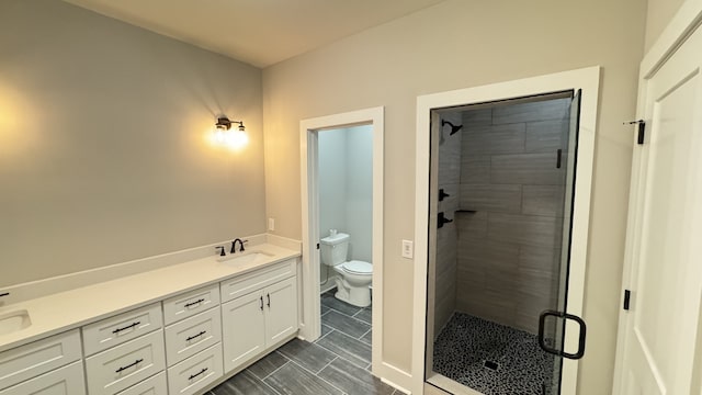 bathroom with a shower with door, tile floors, toilet, and vanity