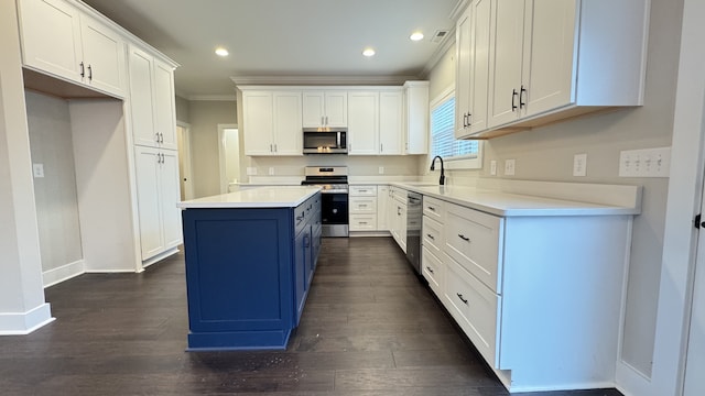 kitchen with white cabinets, a kitchen island, dark hardwood / wood-style flooring, and stainless steel appliances