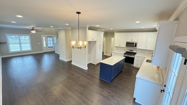 kitchen featuring decorative light fixtures, stainless steel appliances, white cabinets, and dark hardwood / wood-style flooring