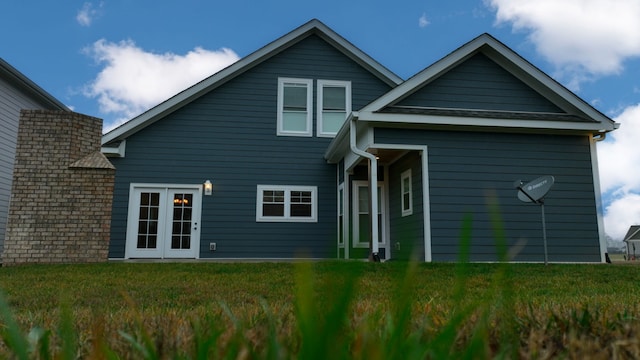 back of house featuring french doors and a lawn