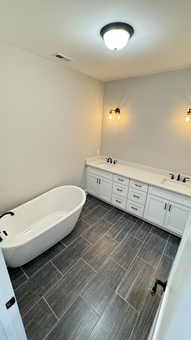 bathroom with dual bowl vanity and a bathing tub