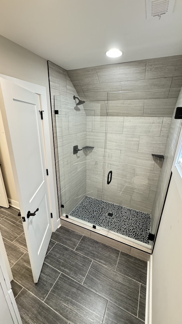 bathroom with an enclosed shower and tile floors