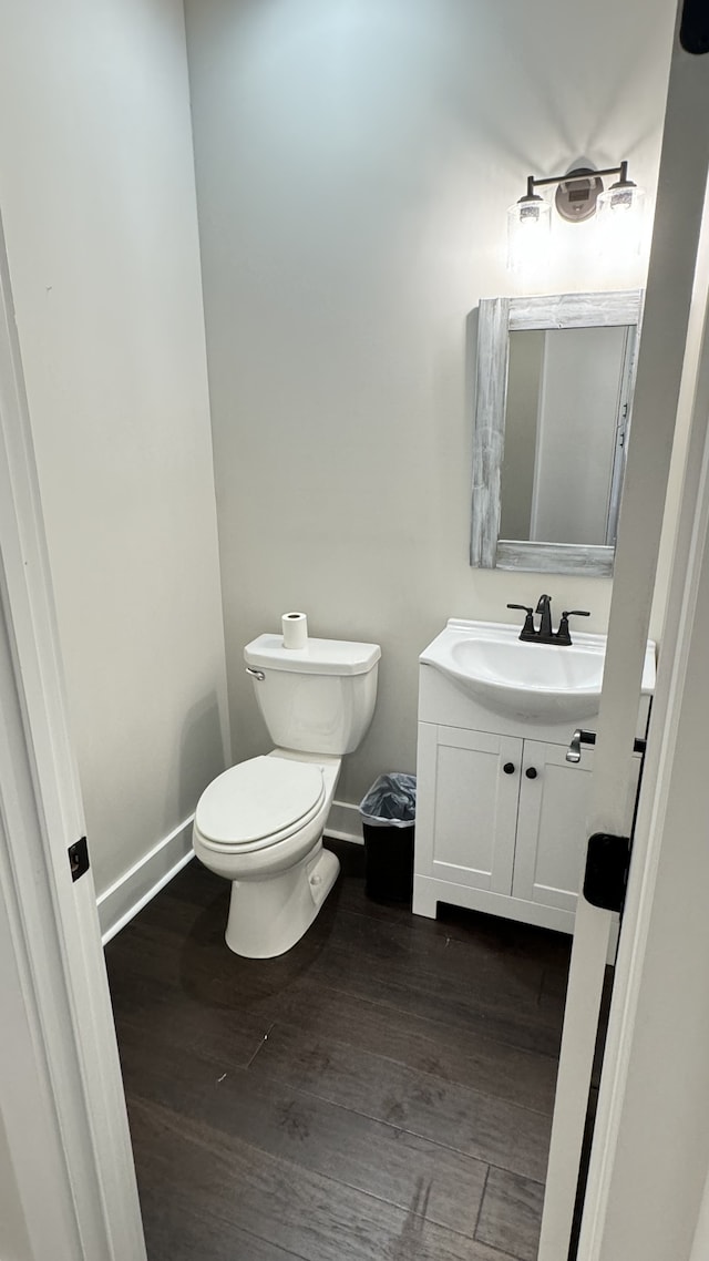 bathroom featuring toilet, vanity, and hardwood / wood-style flooring