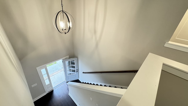 entryway featuring a towering ceiling and dark wood-type flooring