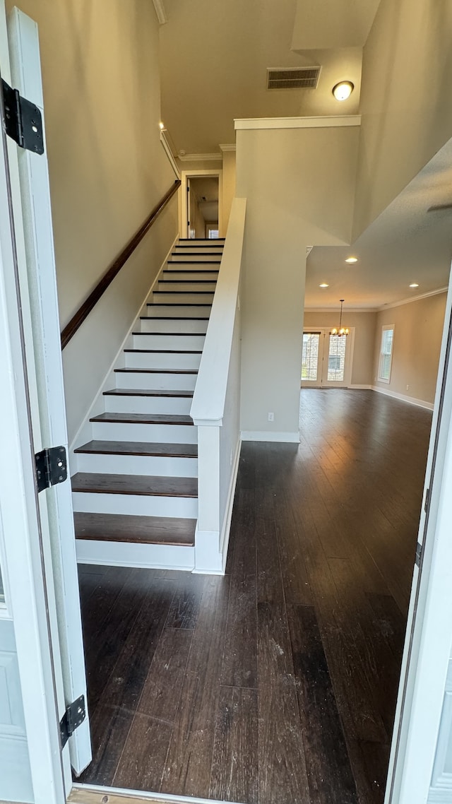 staircase featuring dark hardwood / wood-style flooring and crown molding