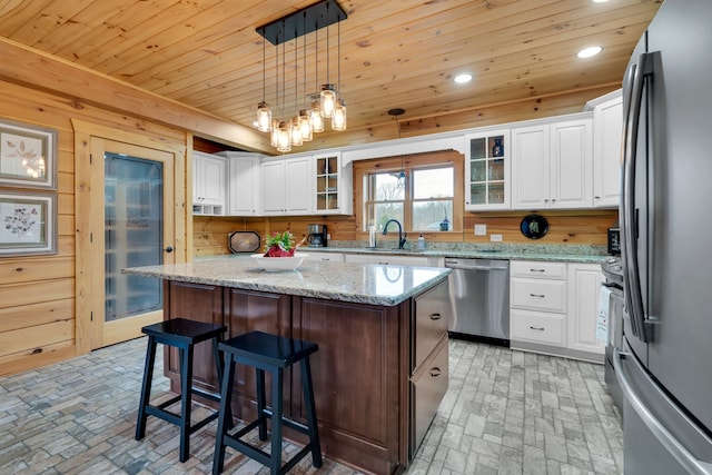 kitchen with stainless steel appliances, decorative light fixtures, a kitchen island, wooden ceiling, and white cabinets